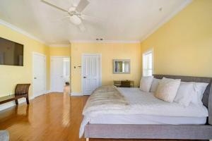 a bedroom with a large bed with a ceiling fan at Luxury Beach House - steps to the beach in Clearwater Beach