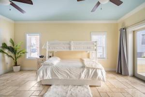 a bedroom with a bed and a ceiling fan at Luxury Beach House - steps to the beach in Clearwater Beach