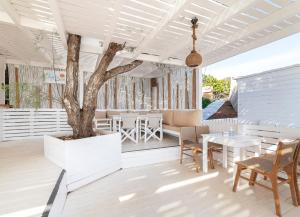 a patio with a tree and a table and chairs at Hotel Perrakis in Kipri