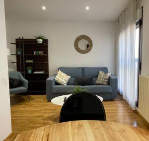 ein Wohnzimmer mit einem blauen Sofa und einem Tisch in der Unterkunft AZ El Balcón de San Felipe in Saragossa