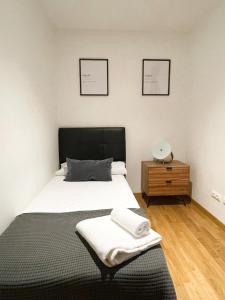 ein Schlafzimmer mit einem Bett, einem Nachttisch und zwei Bildern in der Unterkunft AZ El Balcón de San Felipe in Saragossa
