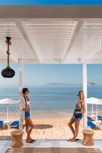 two women walking on the beach near the ocean at Hotel Perrakis in Kipri