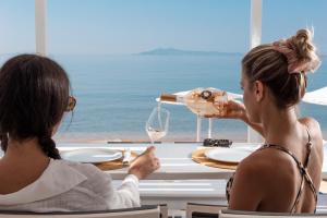 two women sitting at a table with a wine glass at Hotel Perrakis in Kipri