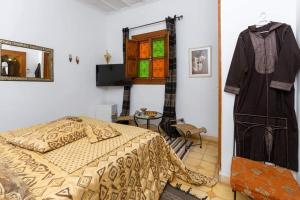 a bedroom with a bed and a shirt hanging on the wall at Riad Aquarelle By GE in Marrakesh