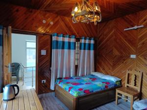 a bedroom with a bed and a chandelier at Hill dew homestay in Uttarkāshi