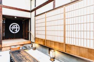 a room with a table and a sign on the wall at Tansada Heritage Machiya in Kyoto +20 photos