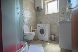 a bathroom with a toilet and a washing machine at Apartman Marenic in Cres