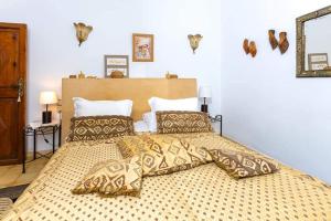 Un dormitorio con una cama grande con almohadas. en Riad Aquarelle By GE en Marrakech