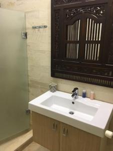 y baño con lavabo blanco y espejo. en El Patio Courtyard House, en Túnez