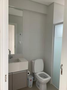 een badkamer met een toilet, een wastafel en een spiegel bij Apto aconchegante e elegante Morretes itapema in Meia Praia