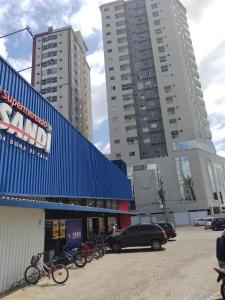 un grupo de bicicletas estacionadas en un estacionamiento junto a edificios altos en Apto aconchegante e elegante Morretes itapema, en Meia Praia
