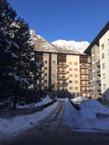 eine schneebedeckte Straße vor einem großen Gebäude in der Unterkunft Appartamento Mont Fleury in Valtournenche