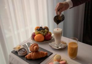 a person is pouring coffee into a breakfast table with food at Ramada by Wyndham Tbilisi Old City in Tbilisi City
