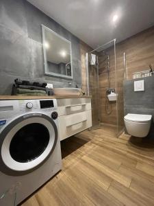 a bathroom with a washing machine and a toilet at Apartament z Widokiem 5 in Chełm