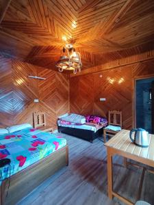 a bedroom with a wooden ceiling with a bed and a table at Hill dew homestay in Uttarkāshi