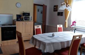een keuken met een tafel met een witte tafeldoek bij Haus Bergfried SORGENFREI BUCHEN in Wieda