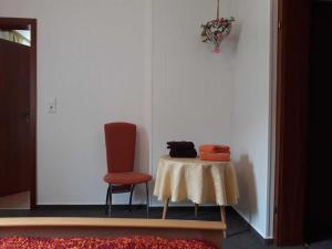 um quarto com uma mesa e uma cadeira vermelha em Haus Bergfried SORGENFREI BUCHEN em Wieda