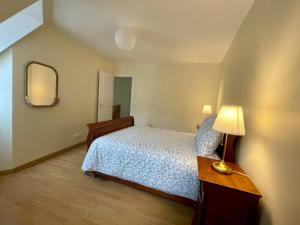 een slaapkamer met een bed, een lamp en een spiegel bij Le Mulberry in Bayeux