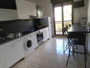 une cuisine avec un lave-linge, un sèche-linge et une table dans l'établissement Chambres dans guest house à Lyon-GARE Part-Dieu, à Lyon