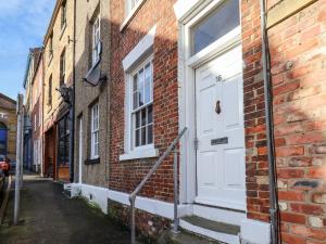 a white door on the side of a brick building at 16 St Sepulchre Street in Scarborough