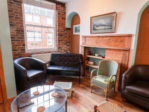 uma sala de estar com mobiliário de couro e uma parede de tijolos em 16 St Sepulchre Street em Scarborough