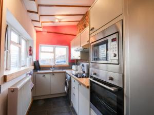 uma pequena cozinha com um lavatório e um micro-ondas em 16 St Sepulchre Street em Scarborough