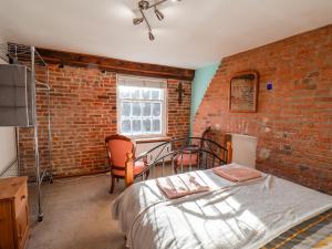 um quarto com uma cama e uma parede de tijolos em 16 St Sepulchre Street em Scarborough