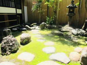 a garden with rocks and a pond with a lantern at Tansada Heritage Machiya in Kyoto