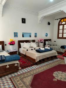 a bedroom with two beds and a red rug at kasbah Riad dar Ahlam in Aït Baha +111 photos