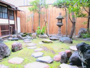 a garden with rocks and a fountain and a fence at Tansada Heritage Machiya in Kyoto