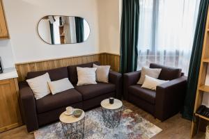 een woonkamer met een bank en een spiegel bij Pirin Golf and Spa Cozy Studio in Bansko