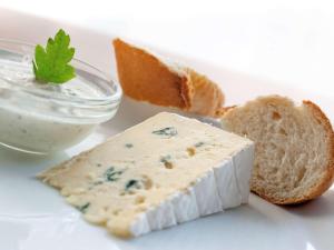 a piece of cheese and bread on a plate with a dip at ibis Berlin Dreilinden in Kleinmachnow