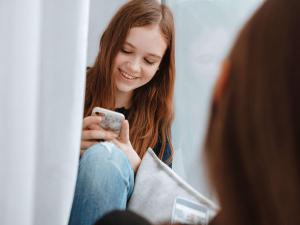 a girl looking at her cell phone in front of a mirror at ibis Berlin Dreilinden in Kleinmachnow