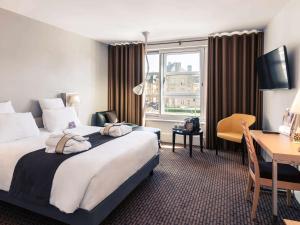 ティオンヴィルにあるHôtel Mercure Thionville Centre Porte du Luxembourgのベッドとデスクが備わるホテルルームです。