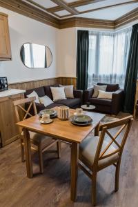 een woonkamer met een tafel en een bank bij Pirin Golf and Spa Cozy Studio in Bansko