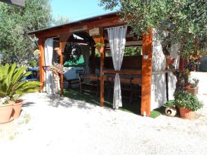 a wooden shed with a bench in a yard at B&B IL PALOMBARO in Uggiano la Chiesa