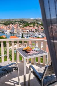 un balcón con mesa y sillas y un bol de fruta en Villa Gaj, en Milna