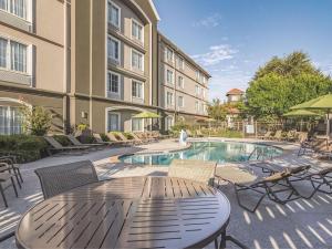 a patio with a table and chairs and a swimming pool at La Quinta by Wyndham Oklahoma City Norman in Norman