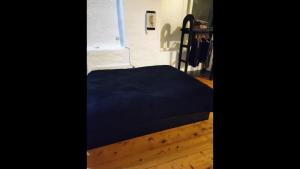 1 cama con manta azul en el suelo de madera en Artemis Studio Pyrgi, en Platis Gialos