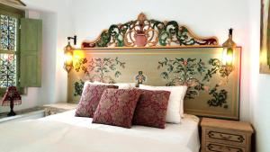 a bedroom with a large bed with a large headboard at El Patio Courtyard House in Tunis
