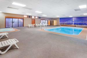 a large pool in a room with tables and chairs at Baymont by Wyndham Perrysburg-Toledo in Perrysburg