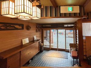 a room with a desk in a room with windows at Sangai Ryokan in Gotsu