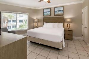 Un dormitorio con una gran cama blanca y una ventana en Palm Beach Resort Orange Beach a Ramada by Wyndham en Orange Beach