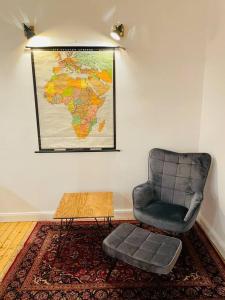 um quarto com uma cadeira e um mapa na parede em Modernes Apartment nahe VW-Halle em Braunschweig