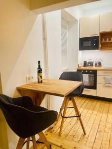 uma cozinha com uma mesa de madeira e 2 cadeiras em Modernes Apartment nahe VW-Halle em Braunschweig
