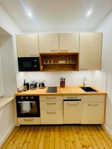 uma cozinha com armários brancos e piso em madeira em Modernes Apartment nahe VW-Halle em Braunschweig