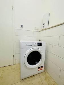 uma máquina de lavar e secar roupa num quarto branco em Modernes Apartment nahe VW-Halle em Braunschweig