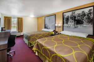 a hotel room with two beds and a tv at Super 8 by Wyndham Kinder/Coushatta near Casino in Kinder