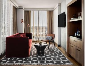 a living room with a red couch and a large window at Thompson Atlanta - Buckhead, by Hyatt in Atlanta