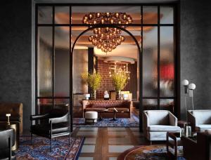 un soggiorno con divano e lampadario pendente di Thompson Atlanta - Buckhead, by Hyatt ad Atlanta